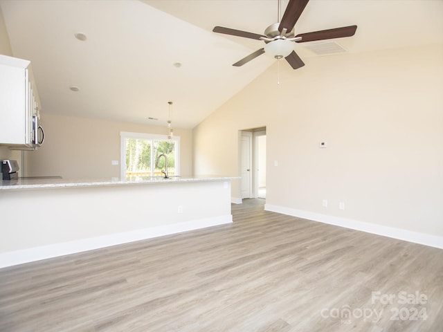 unfurnished living room featuring light hardwood / wood-style floors, high vaulted ceiling, and ceiling fan