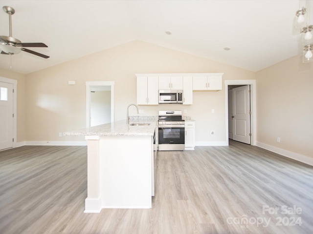 kitchen featuring stove, sink, vaulted ceiling, light hardwood / wood-style floors, and white cabinetry