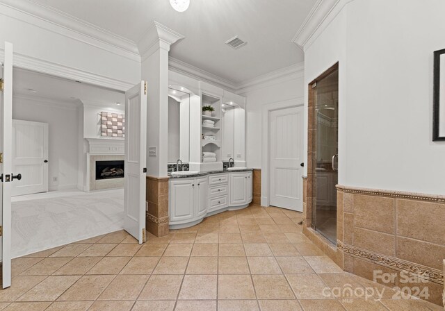 bathroom with ornamental molding, a tile fireplace, vanity, an enclosed shower, and tile patterned floors