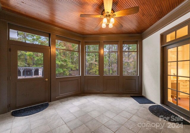 unfurnished sunroom with wood ceiling and ceiling fan