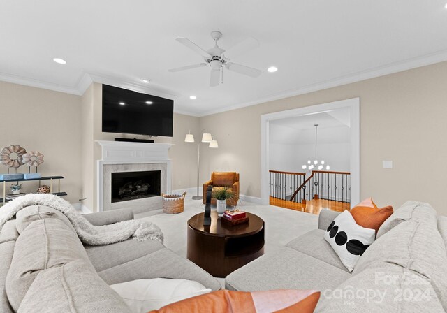 living room with crown molding, ceiling fan with notable chandelier, and hardwood / wood-style floors