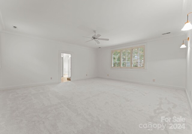 carpeted spare room with crown molding and ceiling fan