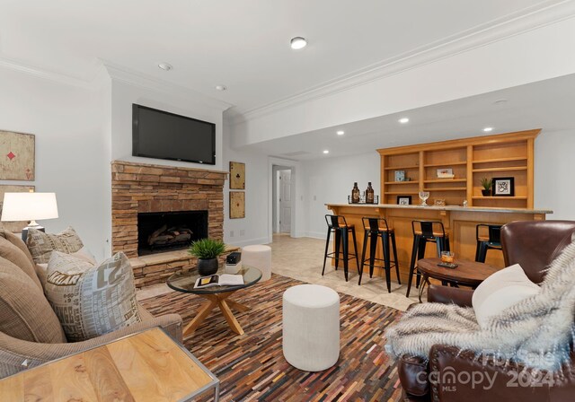 living room featuring crown molding, a fireplace, and bar area