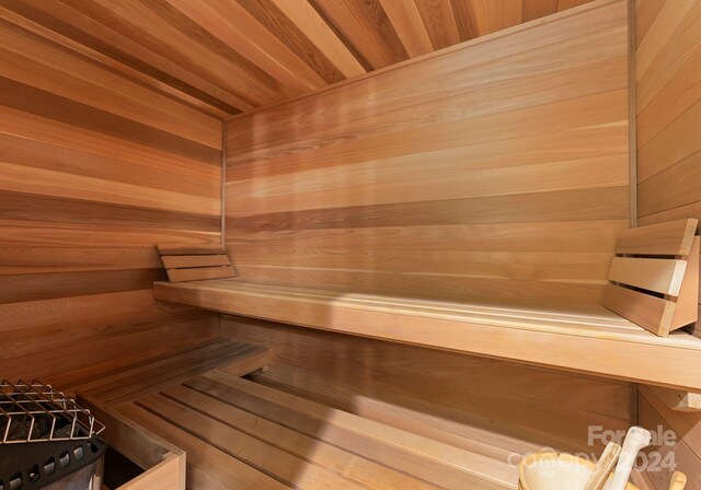 view of sauna / steam room featuring wood ceiling and wood walls