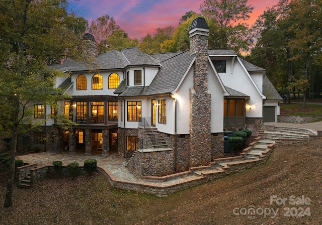 back house at dusk with a patio area