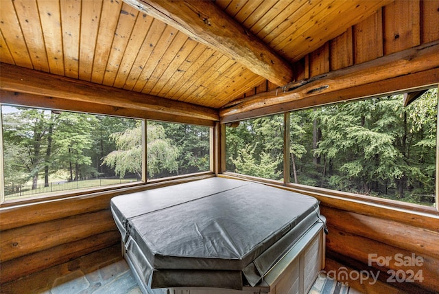 sunroom / solarium with a hot tub, wood ceiling, a healthy amount of sunlight, and lofted ceiling with beams