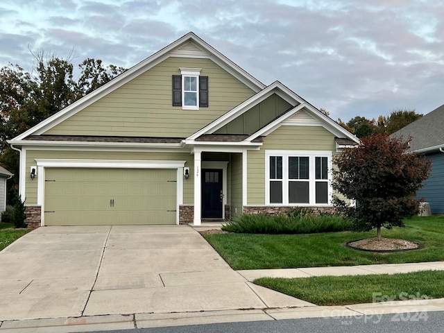 view of front of home featuring a front yard and a garage