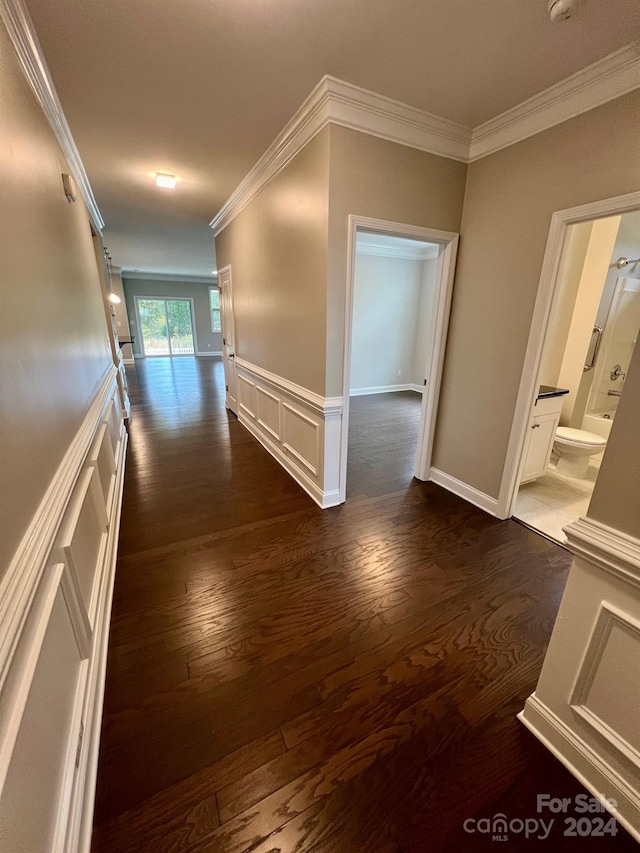 hallway with ornamental molding and dark hardwood / wood-style flooring