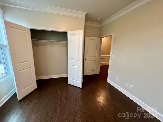 unfurnished bedroom featuring crown molding, dark hardwood / wood-style floors, and a closet