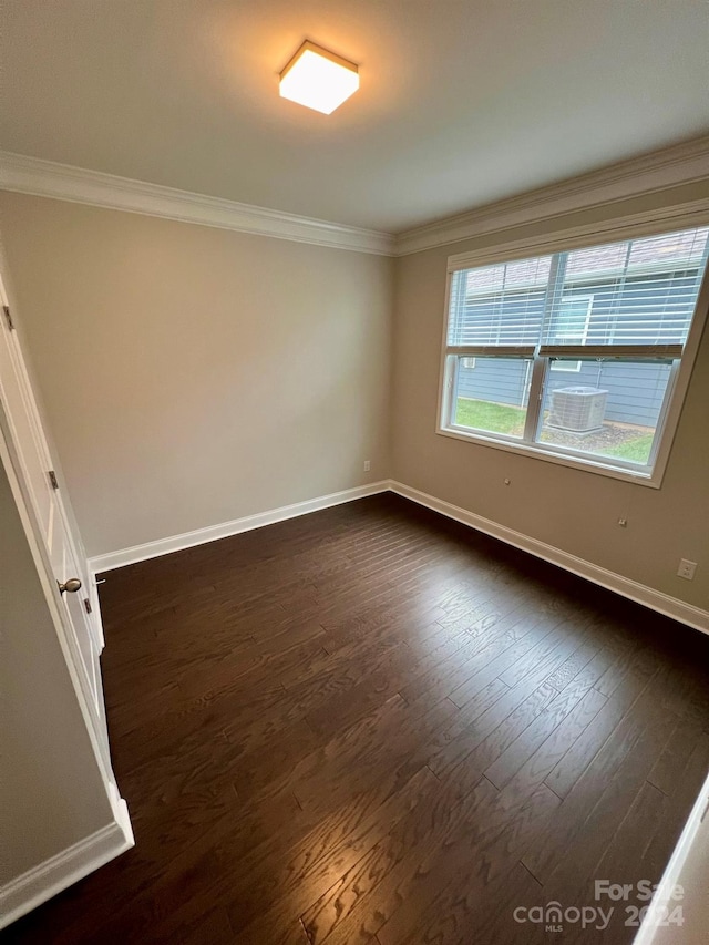 spare room with dark wood-type flooring and crown molding