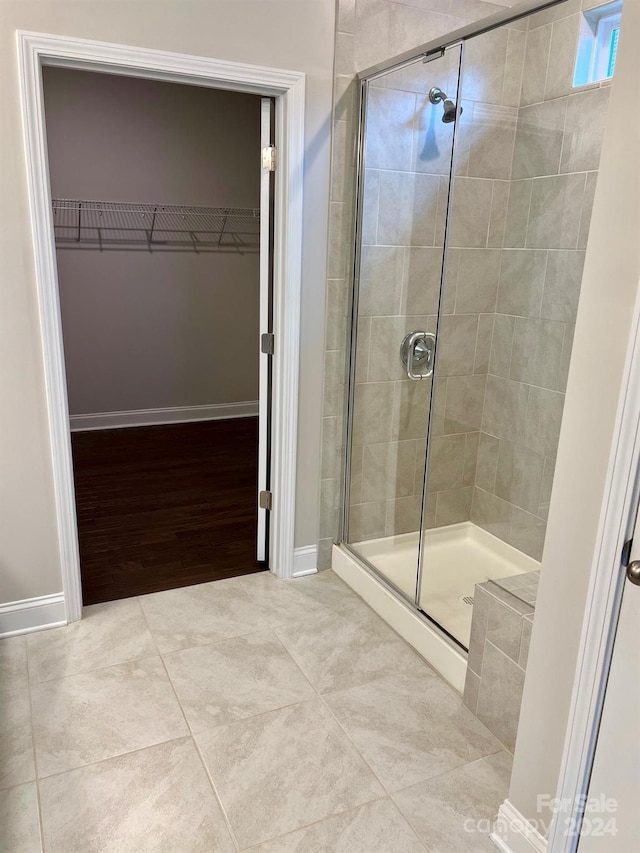 bathroom with wood-type flooring and an enclosed shower