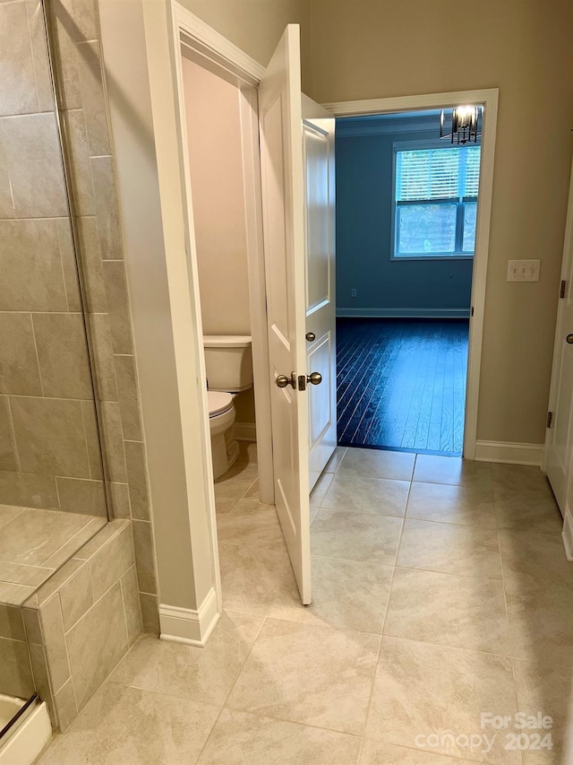 bathroom featuring toilet, hardwood / wood-style flooring, and a shower with shower door