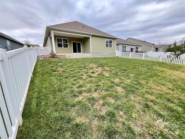 rear view of house featuring a lawn