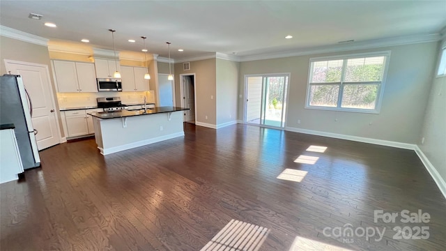 kitchen with stainless steel appliances, dark countertops, dark wood-type flooring, ornamental molding, and white cabinets