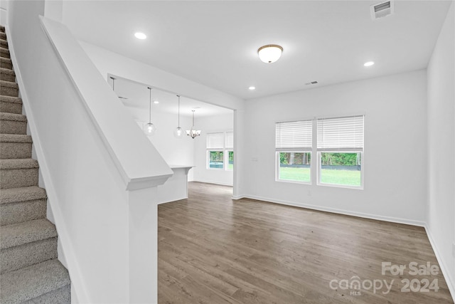 interior space with hardwood / wood-style floors and an inviting chandelier