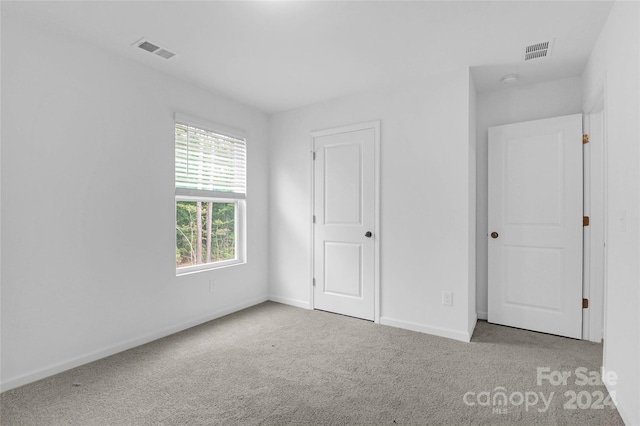 unfurnished bedroom with light colored carpet