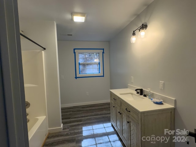 bathroom featuring vanity, bathtub / shower combination, and hardwood / wood-style flooring