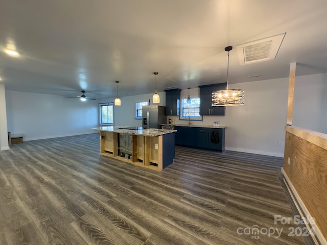 kitchen with a kitchen island, dark wood-type flooring, stainless steel fridge, decorative light fixtures, and ceiling fan