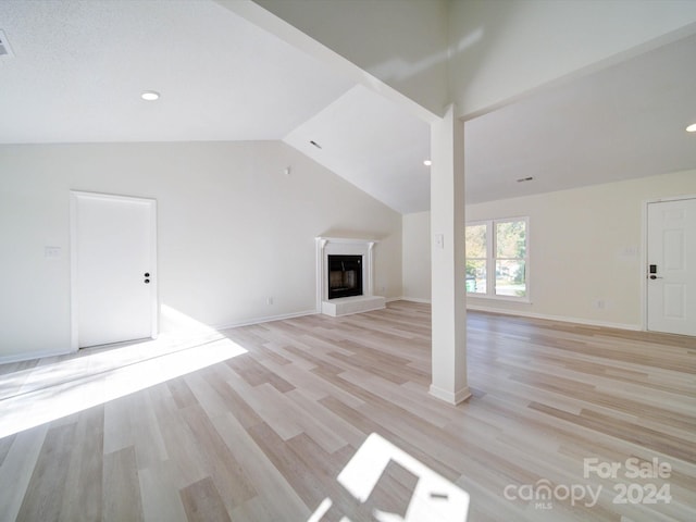 unfurnished living room with high vaulted ceiling and light wood-type flooring