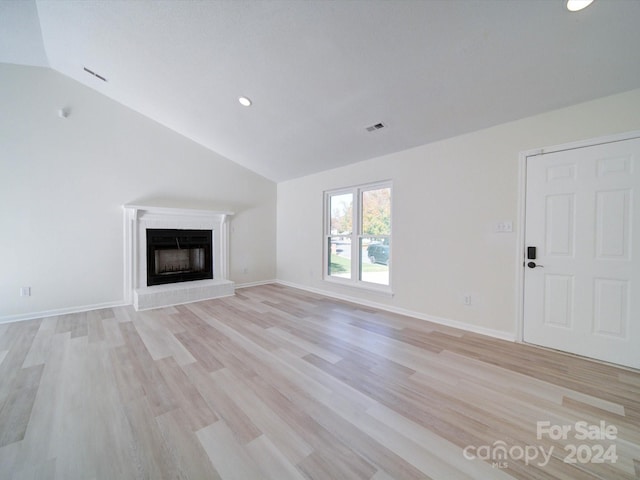 unfurnished living room with light hardwood / wood-style floors and vaulted ceiling