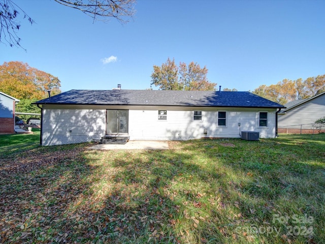 rear view of house with a patio, cooling unit, and a lawn