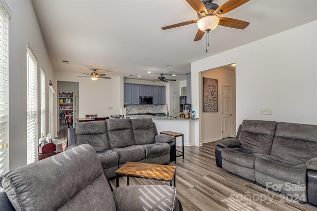 living room with ceiling fan and light wood-type flooring