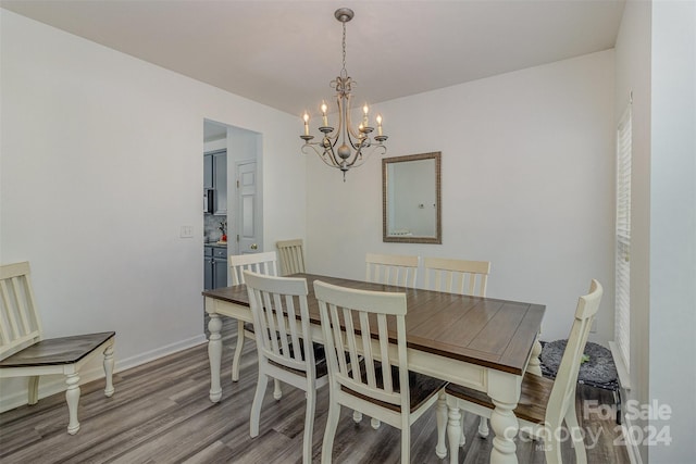 dining room with light wood-type flooring and a chandelier