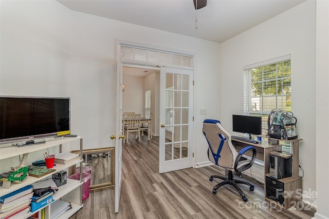 office with hardwood / wood-style flooring, ceiling fan, and french doors