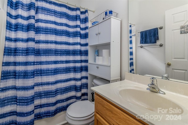 bathroom with curtained shower, vanity, and toilet