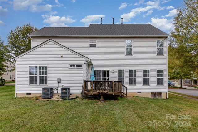 rear view of property with central air condition unit, a lawn, and a wooden deck