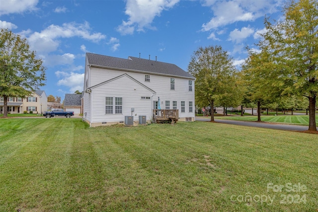 back of house featuring central AC unit, a lawn, and a deck