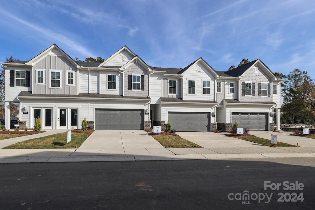 2033 Bayou Dr, Charlotte, NC 28262 - townhome / multi-family property with an attached garage, driveway, and stone siding