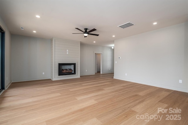 unfurnished living room featuring recessed lighting, visible vents, a fireplace, and light wood-style flooring