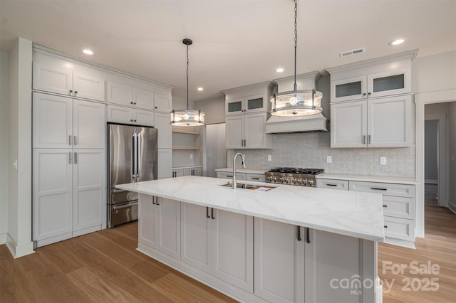 kitchen with stainless steel appliances, light wood-type flooring, a sink, and visible vents