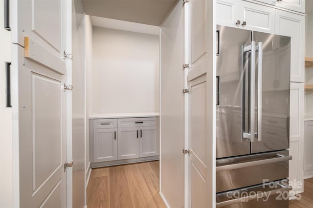 kitchen featuring light wood-style floors, freestanding refrigerator, and white cabinets