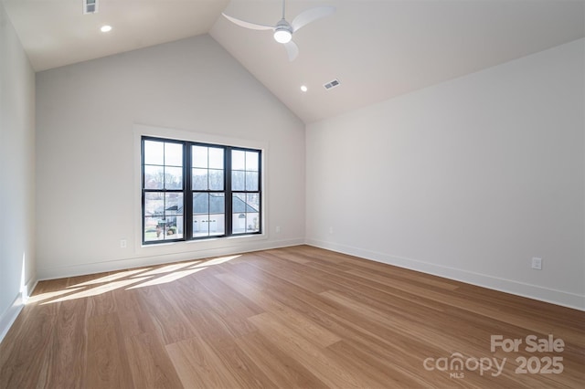 unfurnished room with visible vents, ceiling fan, wood finished floors, high vaulted ceiling, and baseboards