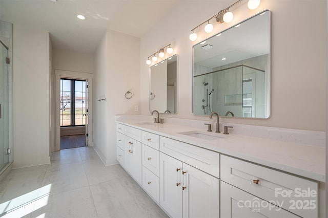 full bathroom with double vanity, a shower stall, and a sink