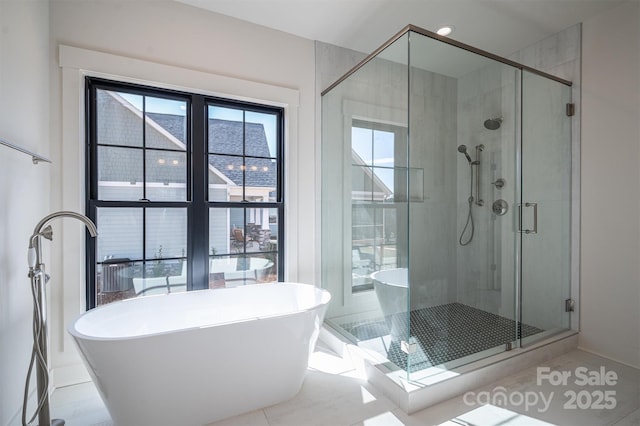 bathroom featuring a stall shower and a freestanding tub