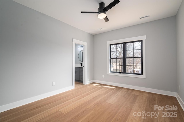 unfurnished room with light wood finished floors, visible vents, a ceiling fan, a sink, and baseboards