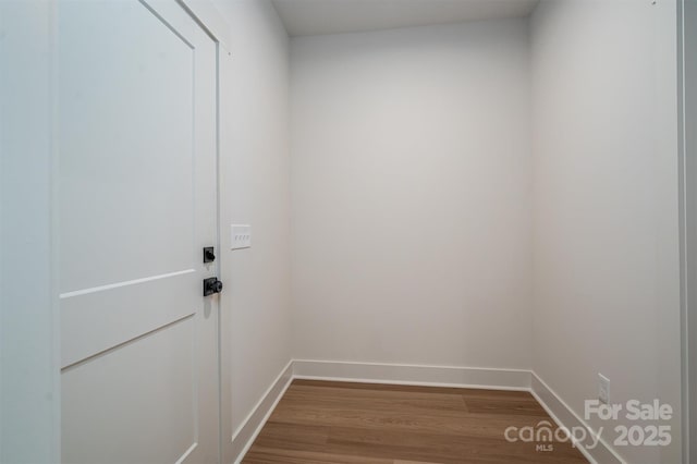 doorway to outside featuring baseboards and dark wood-style flooring