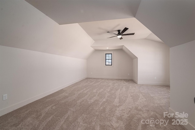 additional living space featuring a ceiling fan, lofted ceiling, baseboards, and carpet