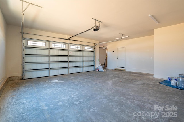 garage featuring a garage door opener and baseboards