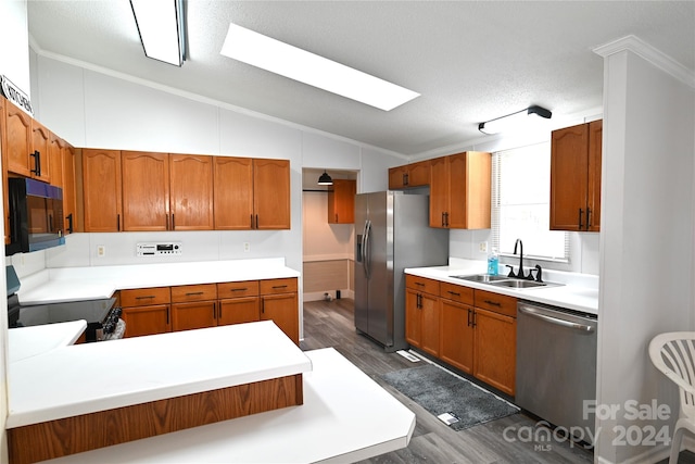 kitchen with sink, a textured ceiling, stainless steel appliances, vaulted ceiling, and dark wood-type flooring