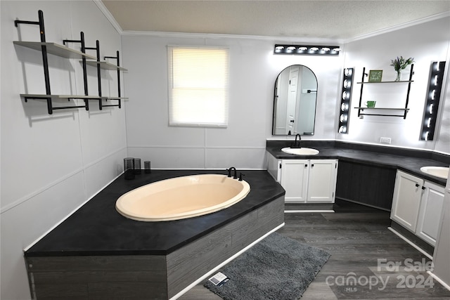 bathroom featuring vanity, hardwood / wood-style floors, ornamental molding, and a tub to relax in