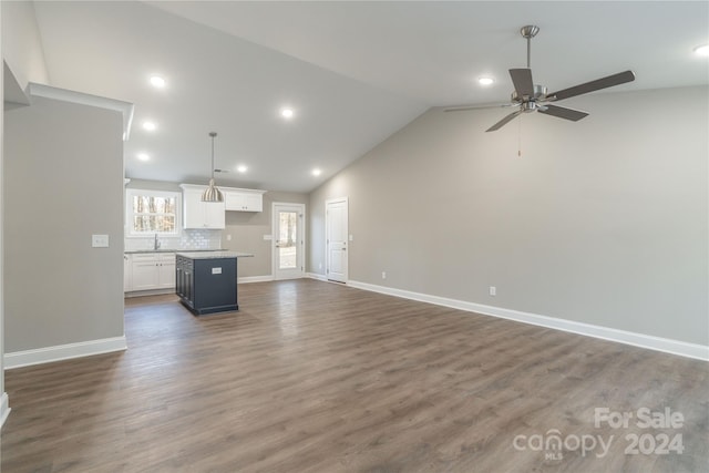 unfurnished living room with dark hardwood / wood-style floors, ceiling fan, lofted ceiling, and sink