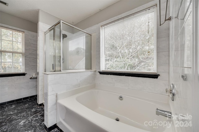 bathroom with independent shower and bath and a textured ceiling