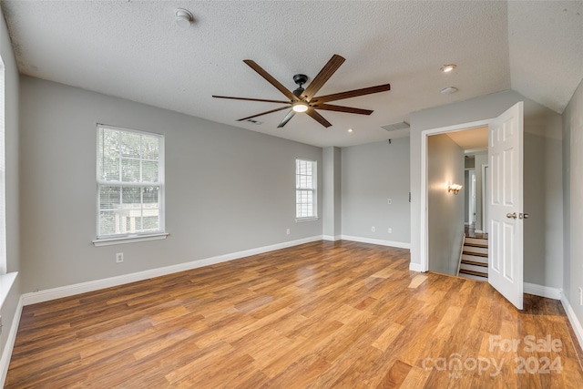 unfurnished room featuring ceiling fan, a textured ceiling, and light hardwood / wood-style flooring