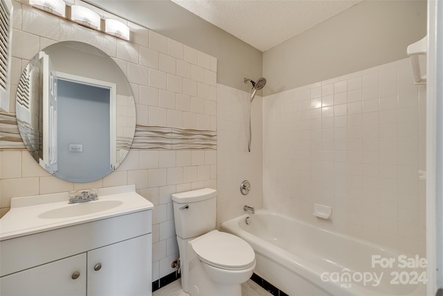 full bathroom featuring toilet, tile walls, tiled shower / bath combo, a textured ceiling, and vanity