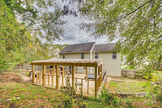 rear view of property with a pergola and a wooden deck