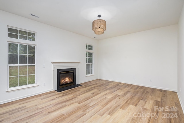 unfurnished living room featuring light hardwood / wood-style flooring and plenty of natural light